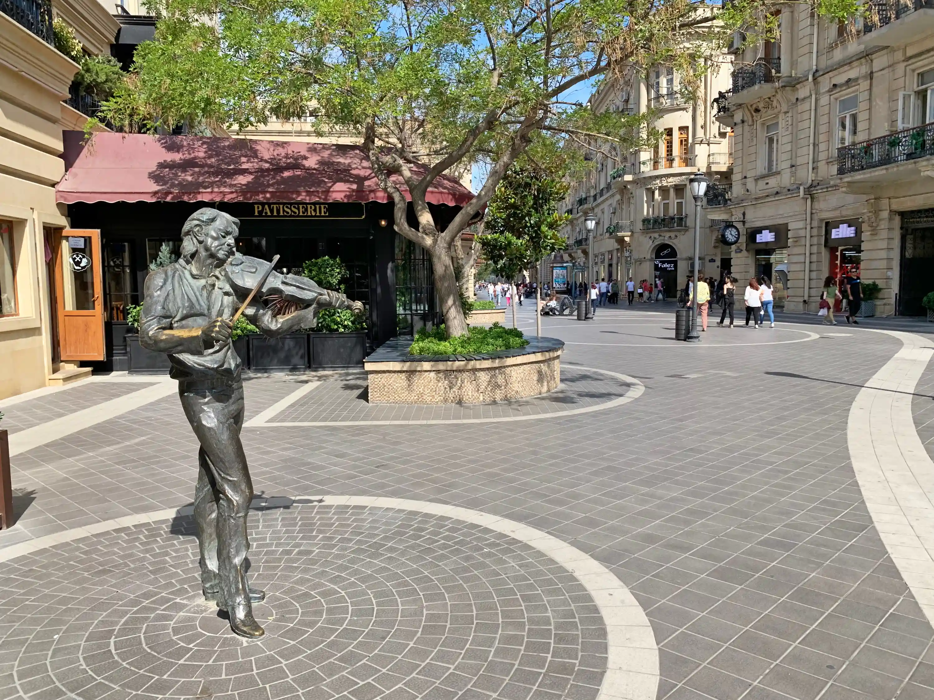 A bronze sculpture of a man playing the violin that represents Nizami Street’s musical performances.